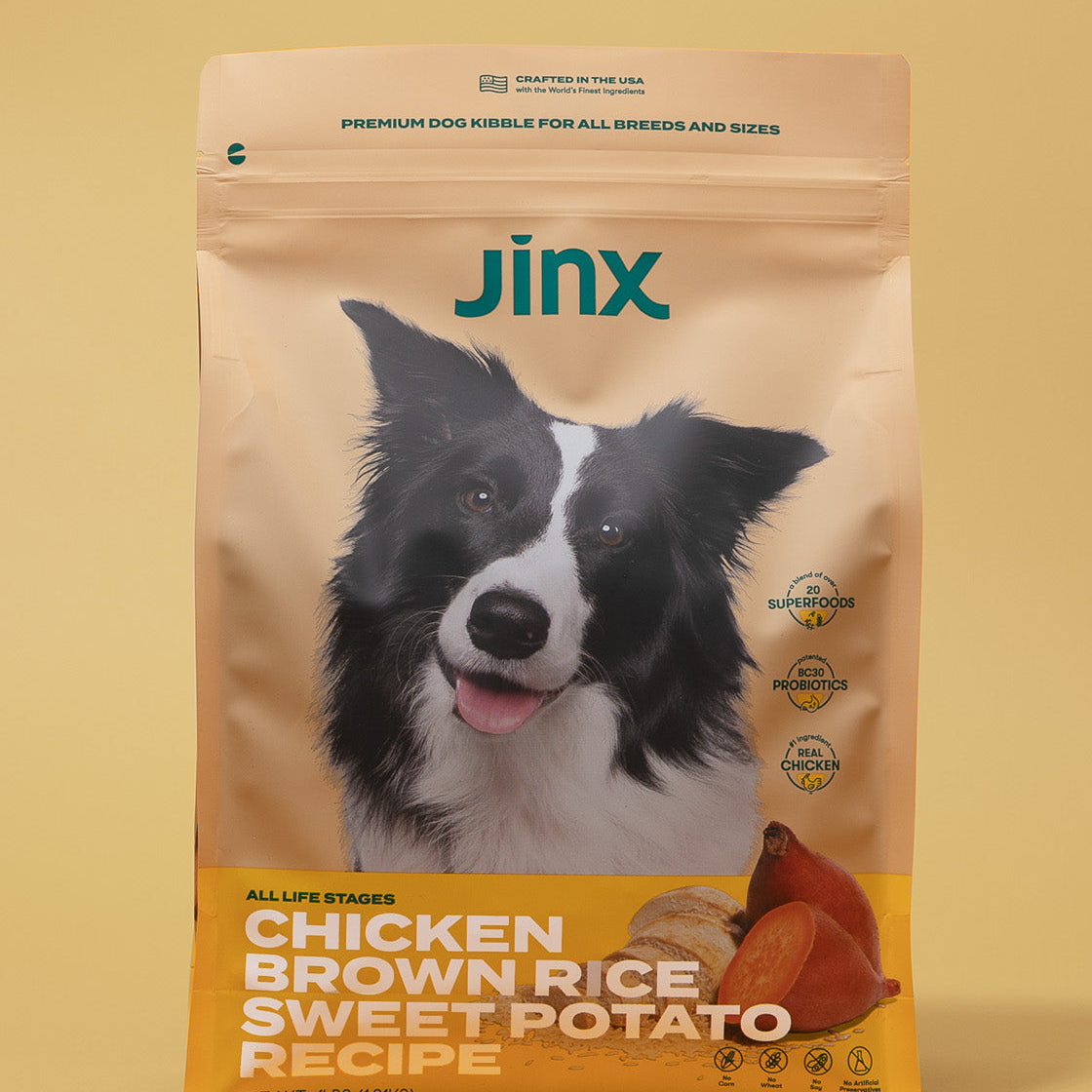Chicken essentials Jinx bundle with chicken, brown rice & sweet potato Jinx dog kibble product packaging on yellow background.