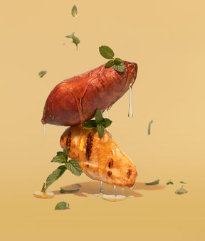 Sweet potato & chicken with parsley dripping with honey artistically hovering in the air on a yellow background.