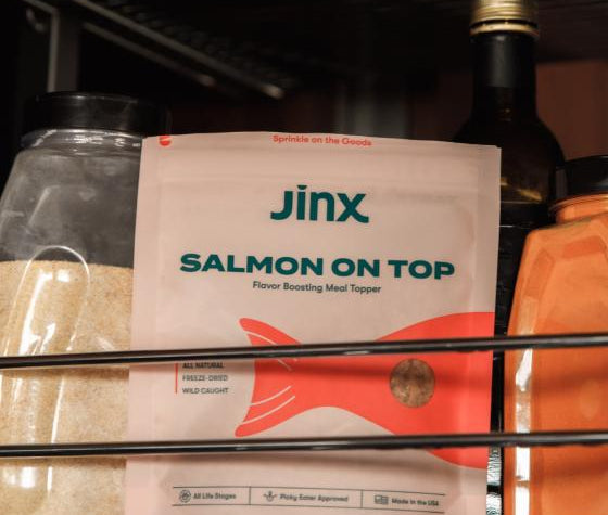 Salmon topper product packaging sitting on a shelf in a pantry amongst other grocery products. 