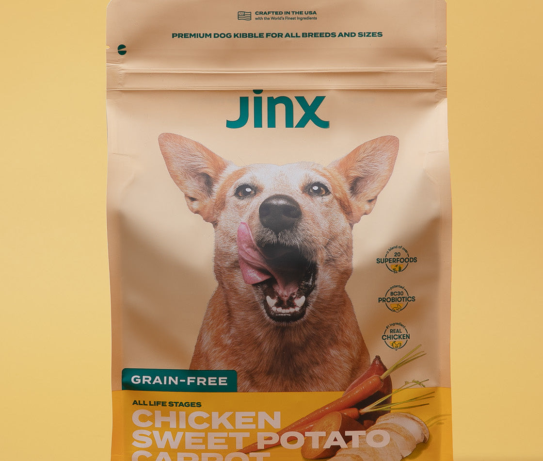 Grain-free chicken essentials Jinx bundle including chicken, sweet potato & carrot Jinx dog kibble product packaging on a yellow background.